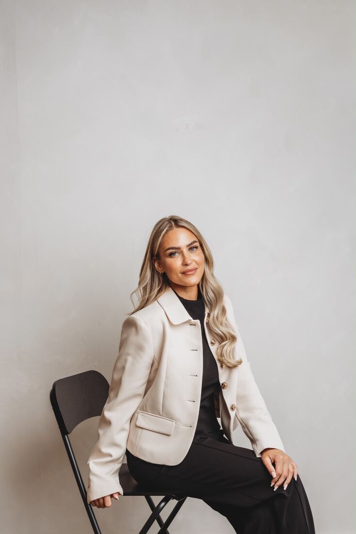 Jade Peel seated in a cream blazer